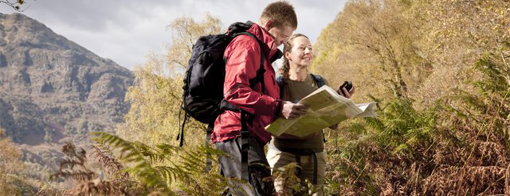 2 walkers looking at a map in the park