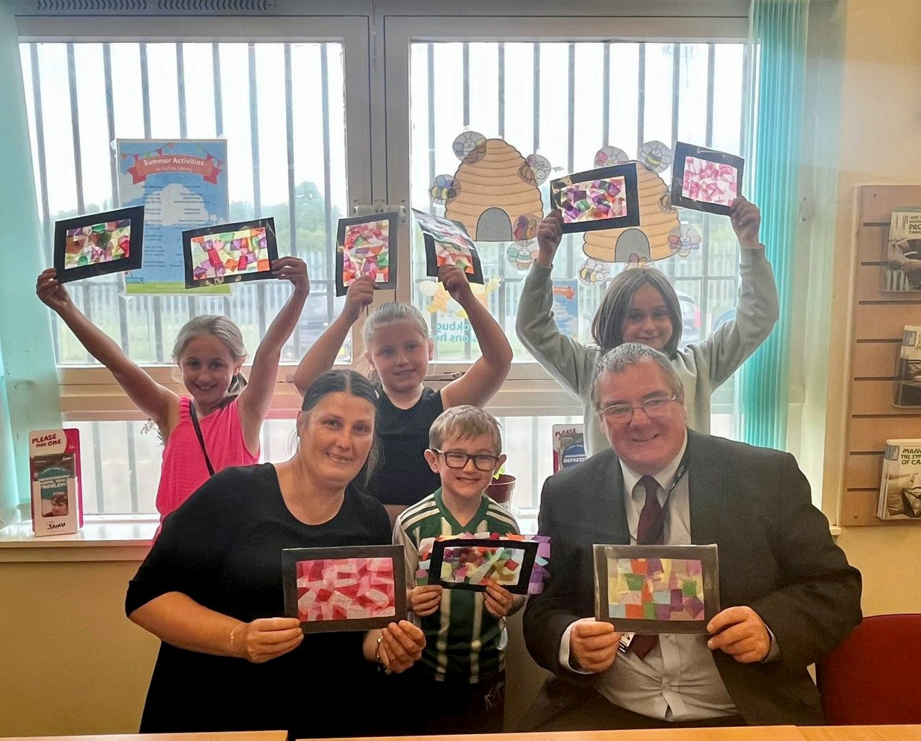 Cllr McGinty and Cllr Lennie with children, holding the stained glass window art they created.