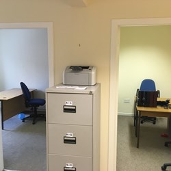 Filing cabinet in between 2 doors leading into offices