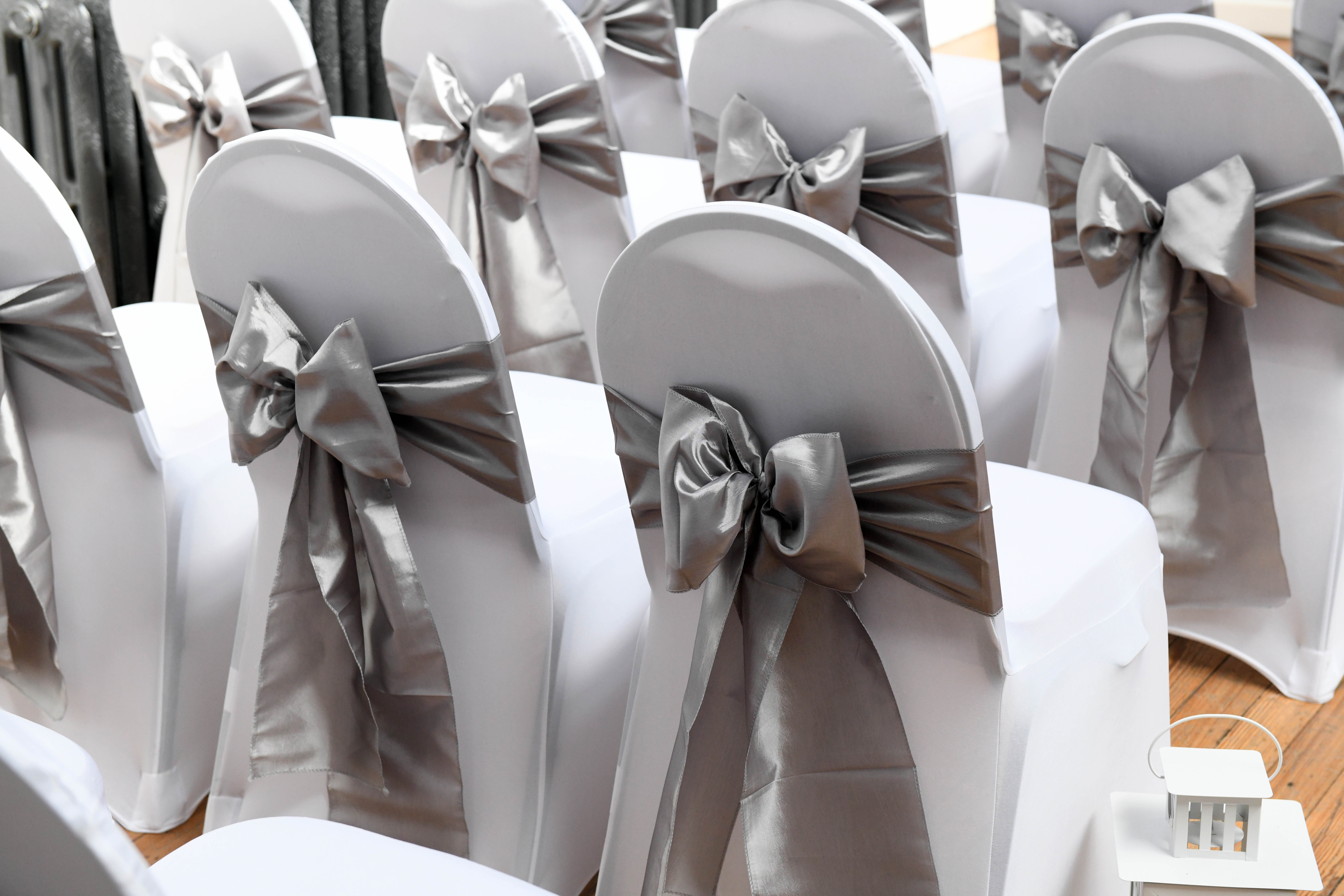 image of Venue Dressing - chairs in white with bows on the back