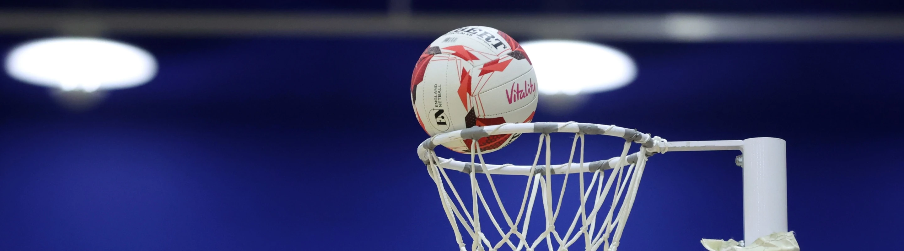 Netball about to go through a netball hoop