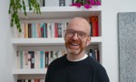 Photo of Matt Haig standing in front of a bookcase 