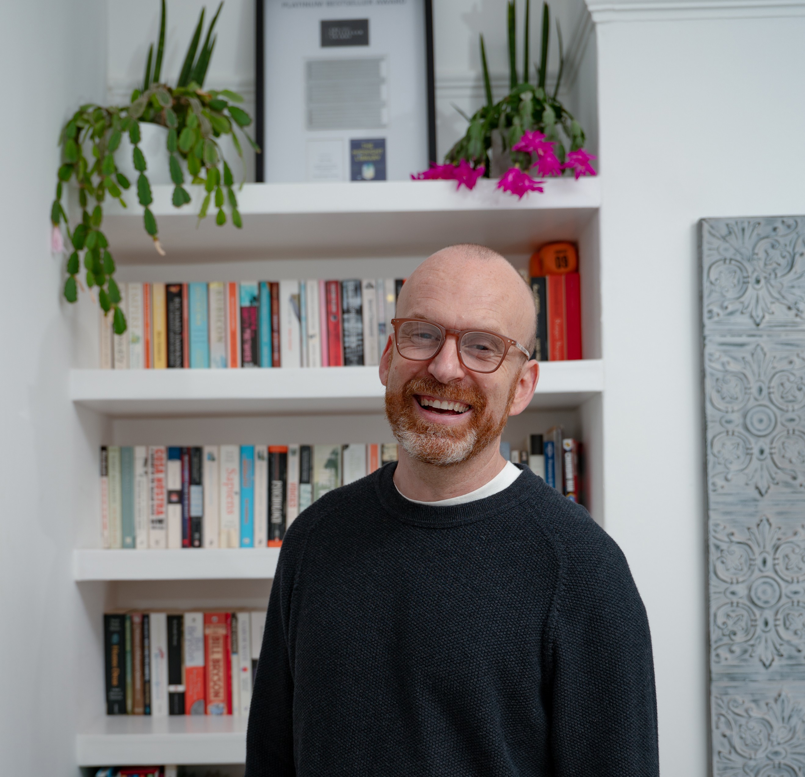 Photo of Matt Haig standing in front of a bookcase 