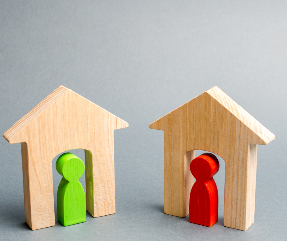Image of two wooden houses with one green figure and one red figure 