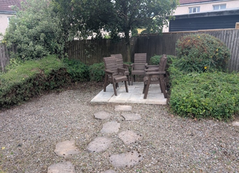 A view of the clean, paved pathway leading towards the back corner of the garden, which will soon house a gazebo.