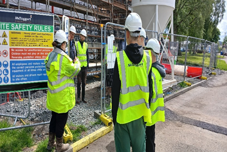 Construction site observation by young apprentices
