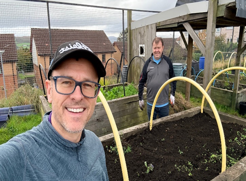 BT volunteers working in Bonhill Community Garden, cutting grass and clearing weeds.