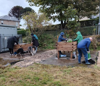 Photo of a raised planter being built or planted by volunteers.