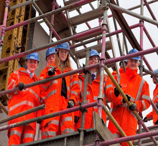 Two pupils working together intently on building a bridge model using construction toys during the STEM workshop.