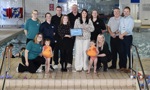 Councillors, West Dunbartonshire Leisure Trust staff and two children with yellow ducks pose with the Scottish Water Learn to Swim Provider of the Year award.