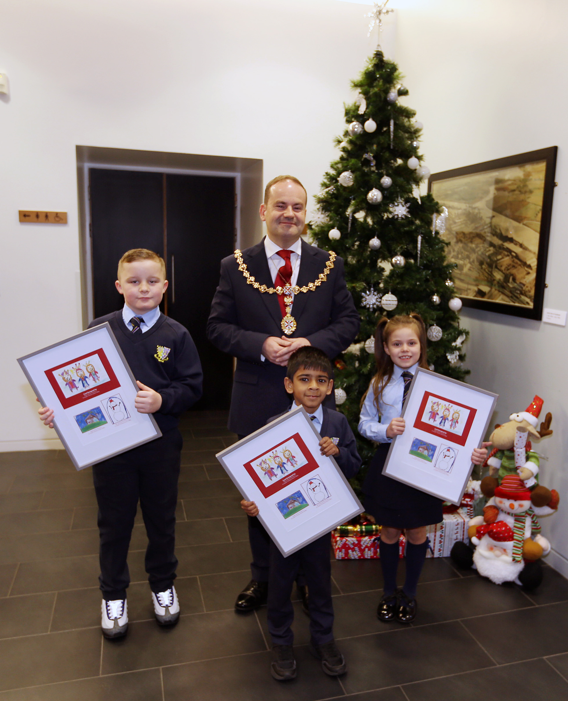 Max McGuinness, Eliezer Renato, Jayden Nicol holding their Christmas card designs with Provost McAllister 
