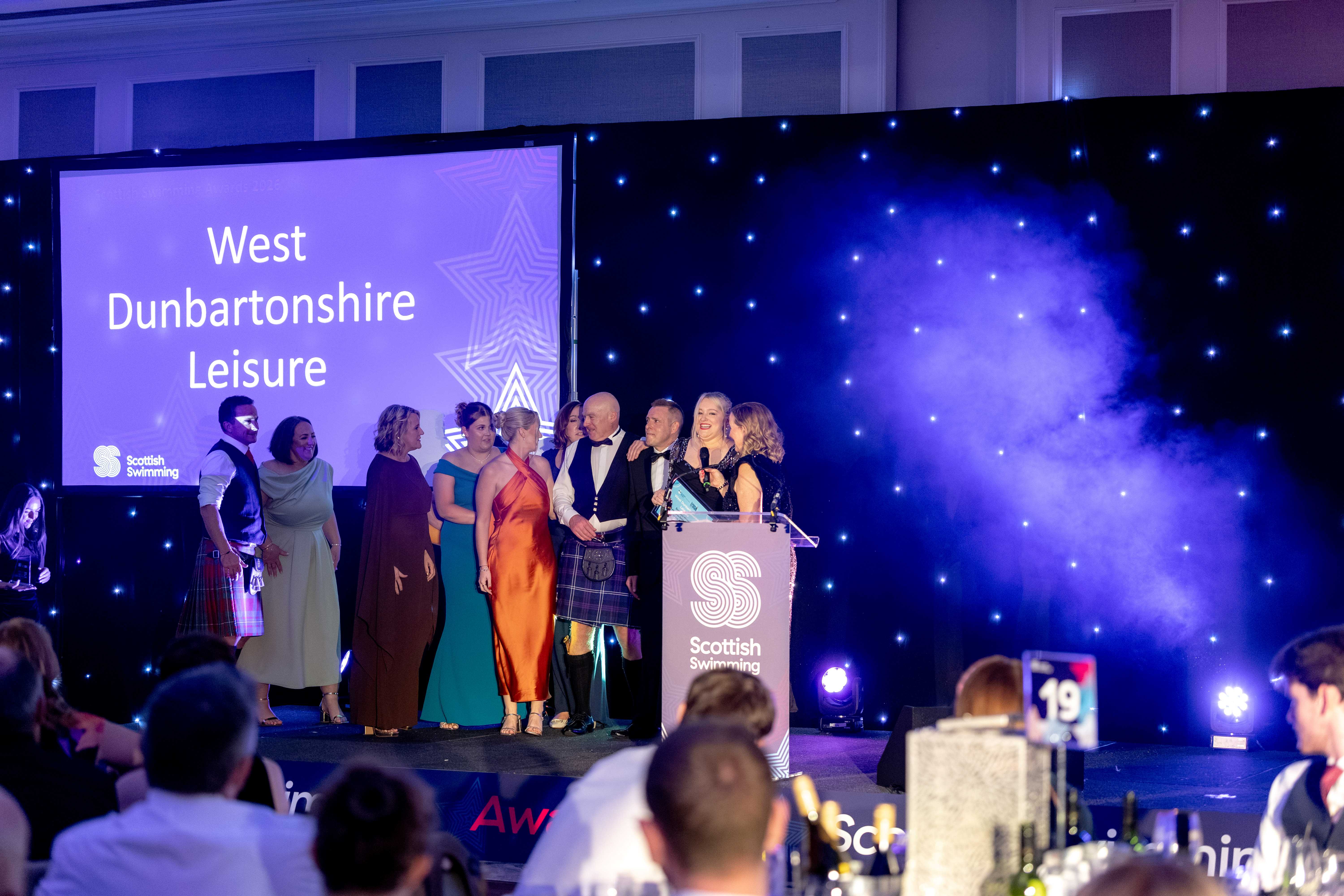 West Dunbartonshire Leisure Trust staff on stage getting the reward